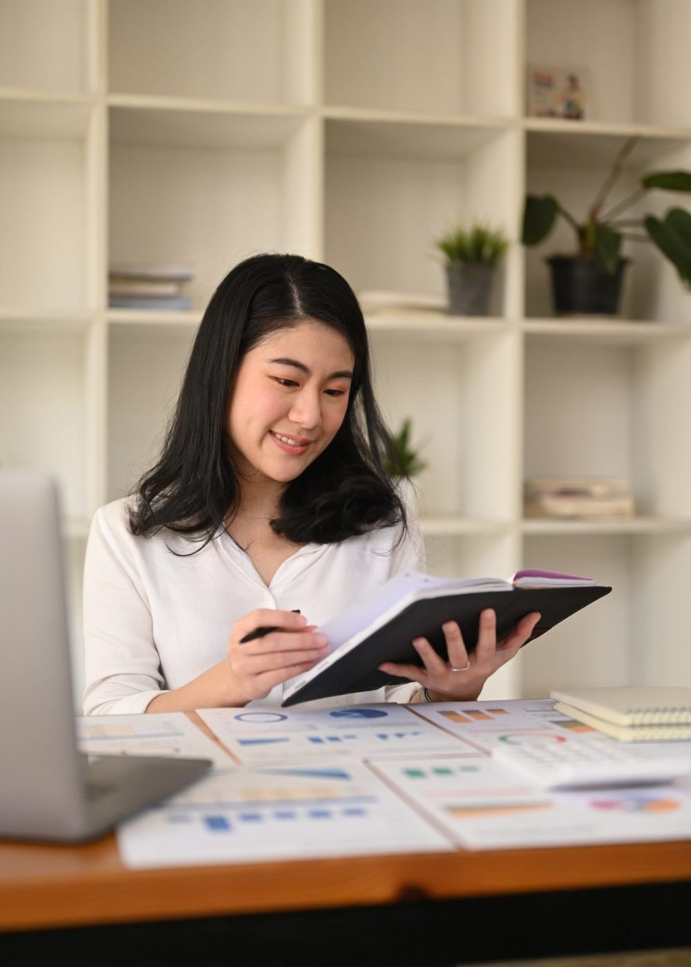 attractive-young-businesswoman-working-with-laptop-and-document-at-corporate-office--e1670796374357.jpg